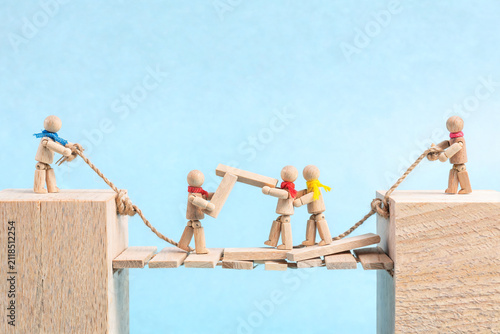 Wooden Figures Building a Bridge Together