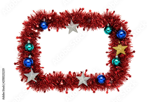 Close-up of a dense, metallic crimson red christmas tinsel garland forming a decorative border with shiny silver stars and reflective blue baubles on a transparent background, central copy space,