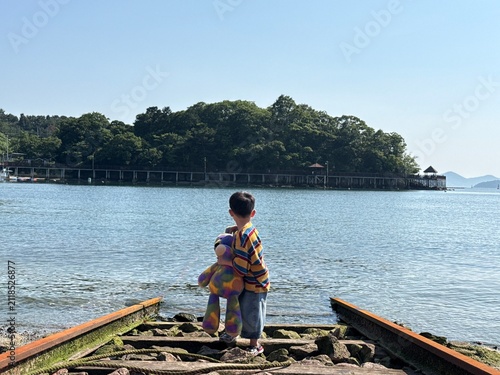 Plakat 바다로 이어진 폐 선로와 꼬마아이 그리고 얼룩 인형 - 뒷모습