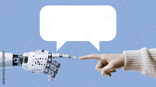 Robot and Human Finger Touch with Speech Bubble: A robotic hand and a human finger touch, reaching towards each other with a blank speech bubble above, symbolizing communication, connection.