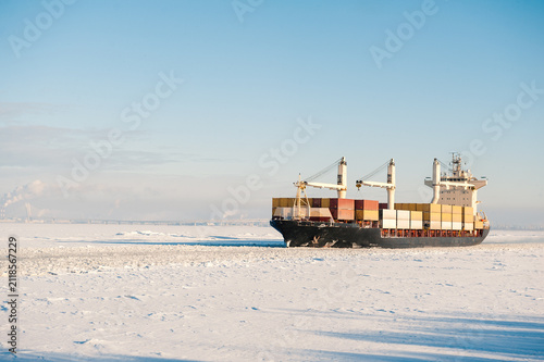 Winter shipping. Cargo ships in frozen ice sea fairway