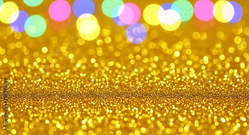 Colorful bokeh lights on golden glittery background