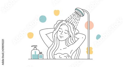 Smiling woman washing her long hair with shampoo in the shower with colorful bubbles and bathroom products in the foreground.