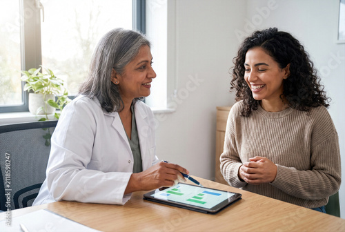 Doctor, physician or medical specialist sharing positive examination, laboratory test, diagnosis or treatment results with patient, couple or family during healthcare consultation, giving good news