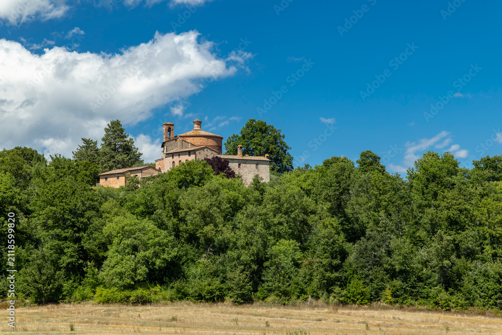 Obraz premium Rotonda di Montesiepi chapel rising above Tuscan landscape