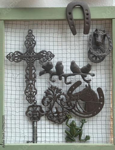 Vintage cast iron decorations cross horseshoe and hooks displayed at an Andalusian craft store, Spain