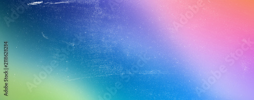 Dreamy rainbow color gradient from deep blue to pink and purple with light scratches and dust texture overlay, abstract backdrop, soft lighting, vintage effect.