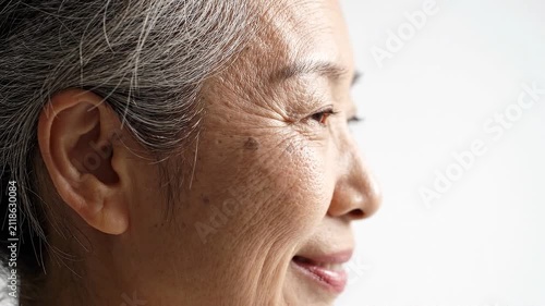 Profile portrait of a beautiful senior asian woman with natural gray hair and wrinkles