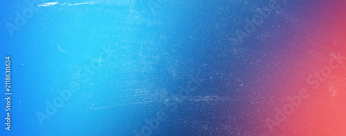 Abstract textured background featuring a gradient transition from bright blue to a softer pinkish-red, evoking a serene and hazy atmosphere.
