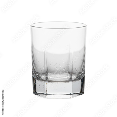 Pristine, empty lowball whiskey tumbler of ultra-clear, heavy crystal glass with hexagonal facets and condensation, isolated on a white background. Concept for luxury drinkware advertising