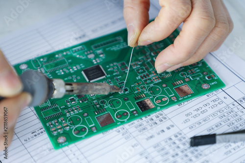 Fotografie Hands soldering electronic circuit board during precision assembly