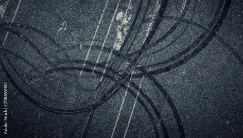Aerial perspective of tire tracks on pavement with lane lines, abstract city texture backdrop, transportation and safety theme.
