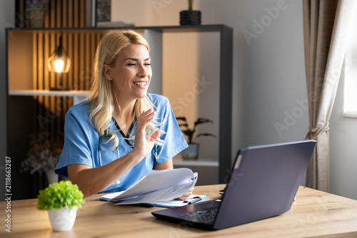 Medical professional having an online video conference with a patient, offering healthcare advice from a home office