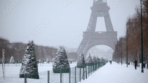Scenic view of the Eiffel Tower in Paris during heavy winter snowfall, evoking a festive and serene holiday mood