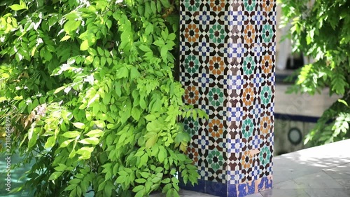 Lush greenery and colorful mosaic columns in the garden courtyard of the Grand Mosque of Paris