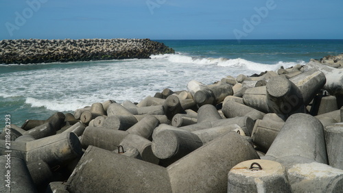 Concrete Tetrapod Wave Breakers on Coastal Shoreline with Ocean Waves