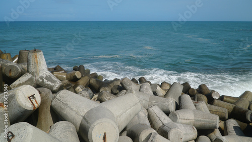 Concrete Tetrapod Wave Breakers on Coastal Shoreline with Ocean Waves