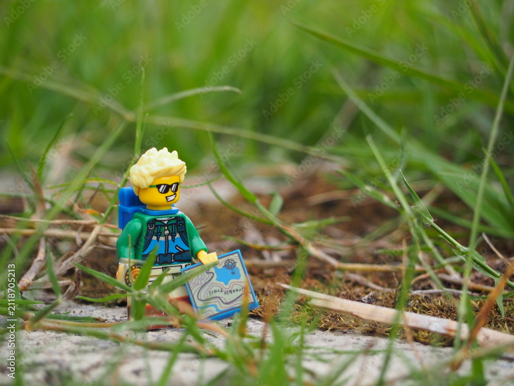 Fototapeta premium Indonesia - November 27, 2019 : Mini toy of action figure at grassland with blurred background. Toy photography concept. Adventure man at grass land conceptual design.