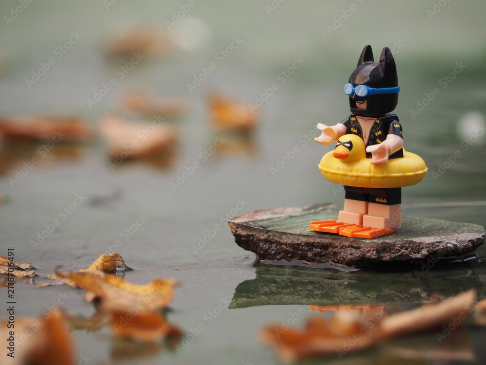 Fototapeta premium Indonesia - November 16, 2018 : Mini toy of action figure at outdoor with blurred background. Toy photography concept design. Batman character from DC Comics film with inflatable rubber.