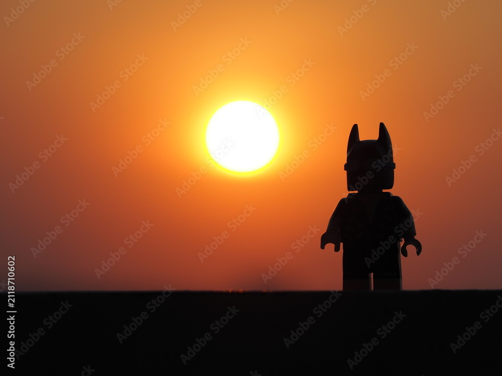Fototapeta premium Indonesia, 26 July 2019. Gorgeous panorama of the sunset with orange sky and the silhouette lego figure. Enjoying relaxing the sunset.