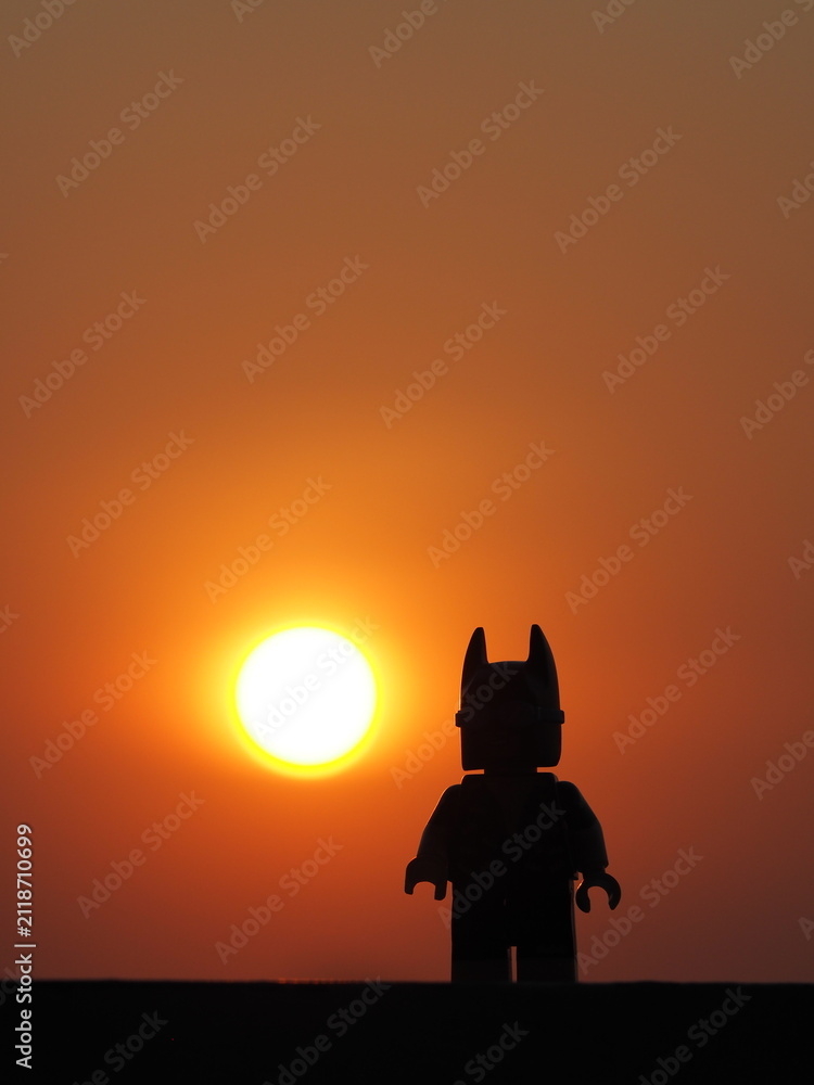 Fototapeta premium Indonesia, 26 July 2019. Gorgeous panorama of the sunset with orange sky and the silhouette lego figure. Enjoying relaxing the sunset.