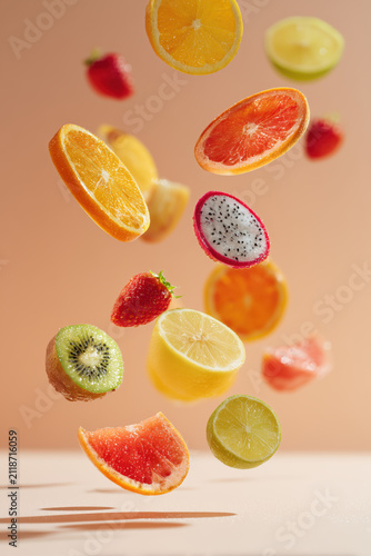 Assorted fresh fruit slices floating mid-air in a dynamic, minimalist composition