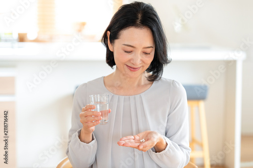 薬を飲むミドル女性 サプリ　服用