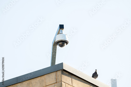 Security surveillance camera mounted on a building rooftop