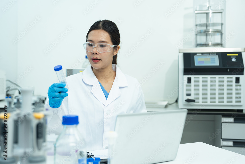 Fototapeta premium Lab work, scientists holds a test tube takes the test from a test tube in analysis for vaccine development.