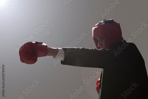 Obraz na plátně Businessman with boxing gloves punching