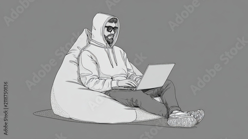 Young man in a hoodie sitting on a bean bag chair using a laptop computer