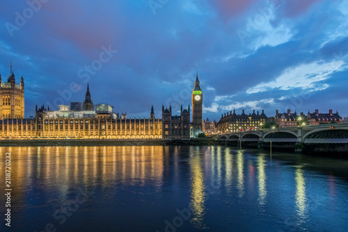 Big Ben and Parliament Buildings at Sunset, dusk and the lights of the building reflecting in the river Thames.