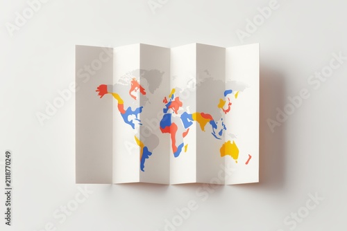 World Map Folded: A neatly folded world map displaying colorful regions, symbolizing global connections and exploration, laid out on a clean, minimalist surface.