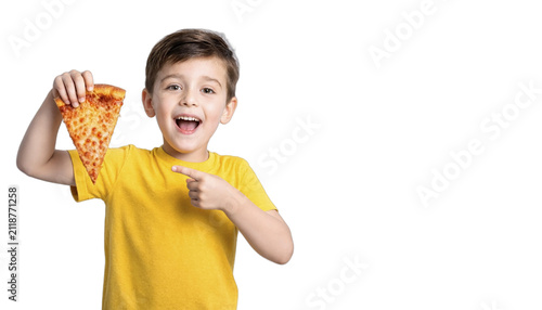 Boy smiling and pointing at a pizza slice while wearing a yellow shirt with copy space on white background. Bright cheerful food concept suitable for family and kids themes.