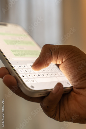 Man hands chatting and typing on smartphone macro closeup.