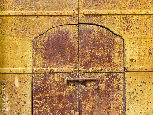 Weathered Metal Door with a large bolt locking mechanism.