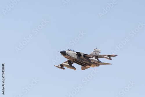 Konstfotografi A tactical military jet fighter plane flying through a clear sky