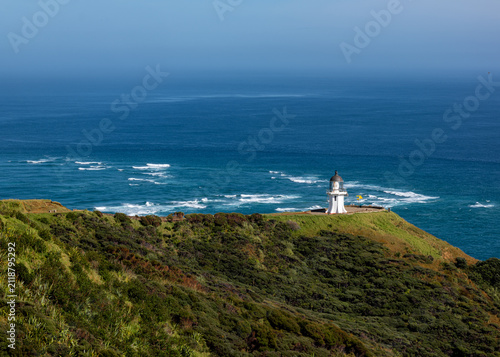 Cape Reinga Leuchtturm, Te Rerenga Wairua, Northland, Neuseeland, Cordyline australis, Phormium tenax, Kuestenlandschaft mit Ozean und Wegweiser