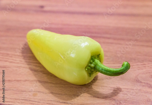 Foto A single Hungarian white wax pepper, also known as TV paprika or tölteni való, lying on a wooden table