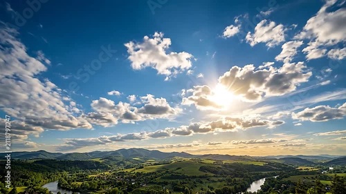A bright sun shines over a lush green valley landscape scene