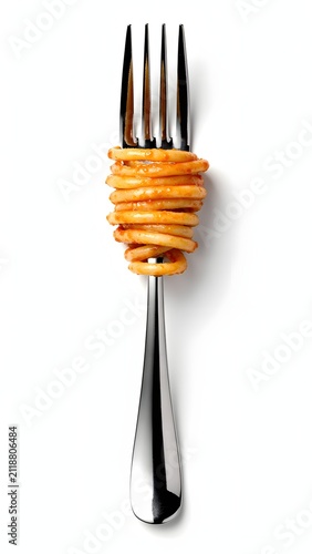 A single silver fork with cooked yellow spaghetti pasta wrapped around the tines isolated on a white background