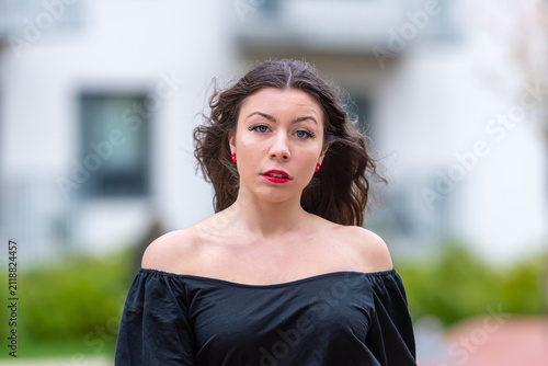Young Woman With Long Hair Poses Outdoors in City During Autumn Afternoon