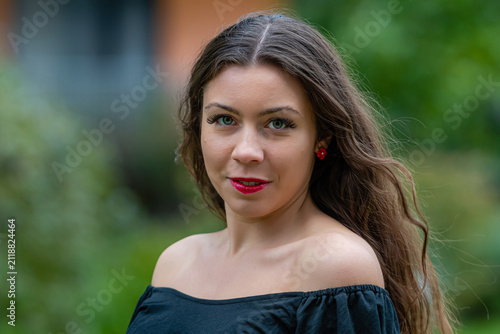 Young Woman With Long Hair Wearing Off-Shoulder Top Posing Outdoors in Urban Setting