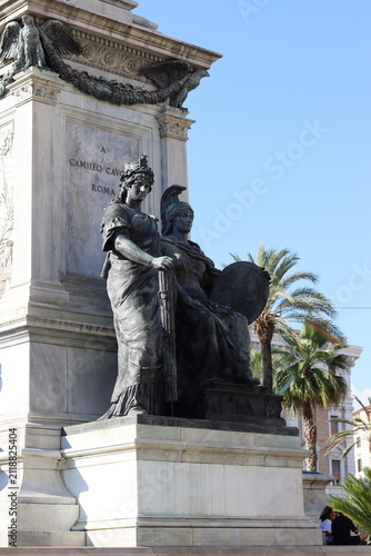 Foto Bronze allegorical figures adorn the base of the Camillo Cavour monument, a marble neoclassical pedestal with palm trees in the background