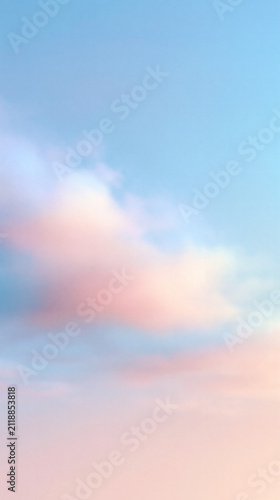 A view of soft pink and blue clouds floating in the bright sky during a peaceful sunset or sunrise time