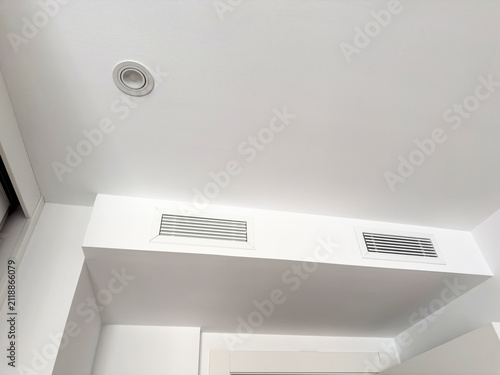 Fotografía A white ceiling bulkhead with two linear air diffusers and a recessed downlight