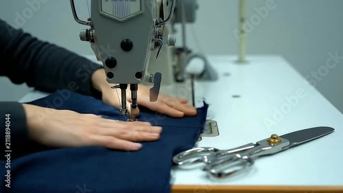 Close-Up of Precision Sewing Techniques with Hands Guiding Fabric at a Sewing Machine in a Studio Environment