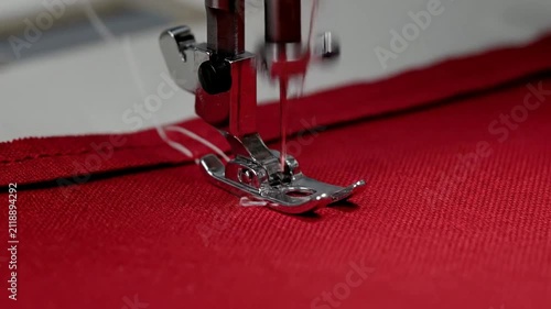 Close-Up Of Sewing Machine Foot Guiding Needle Stitches Through Vibrant Red Fabric In Tailoring Craftsmanship