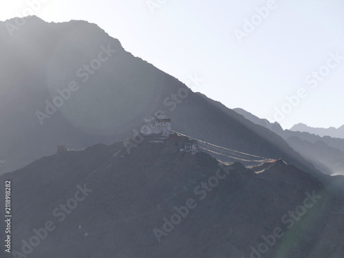 Sunrise light on Tsemo Gompa, Leh monastery on top of the palace, in Ladakh, with lens flare. Scenic travel destination during golden hour