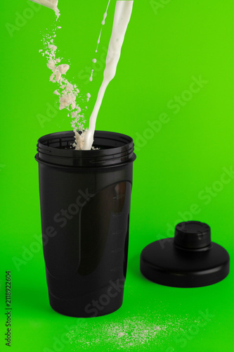 Pouring milk and protein powder into a shaker